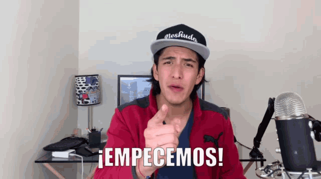 a man wearing a red jacket and a hat that says neshudo