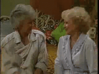 two older women are sitting next to each other in a living room .