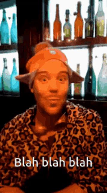 a man wearing an orange hat and a leopard print shirt says blah blah blah .
