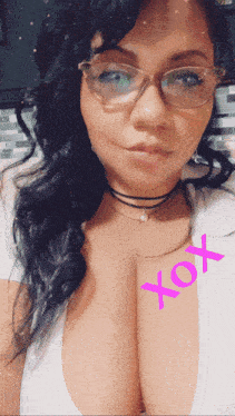 a woman wearing glasses and a choker has a pink xoxo written on her chest