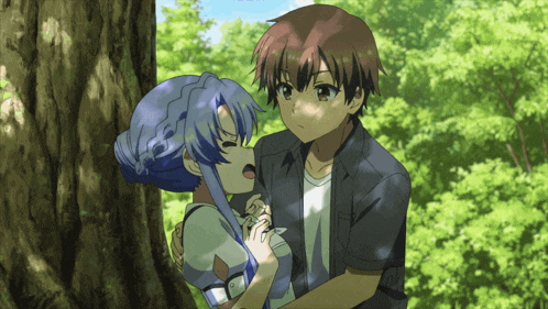 a boy and a girl are kissing in a forest
