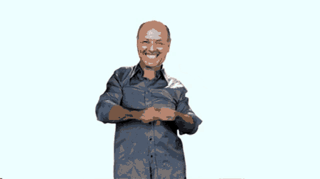 a man in a blue shirt is smiling and making a funny face