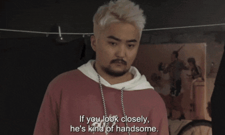 a man with blonde hair and a beard says if you look closely he 's kind of handsome ..