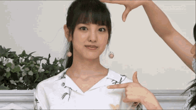 a woman in a white shirt is being pointed at by another person
