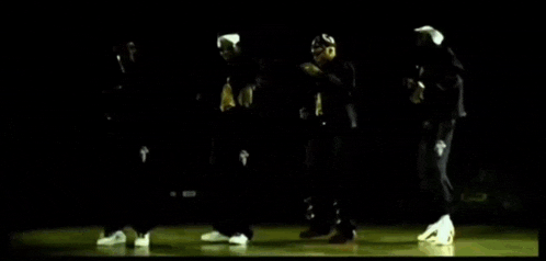 a group of people are dancing together in a dark room .