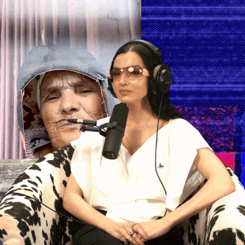 a woman wearing headphones talks into a microphone next to an older woman