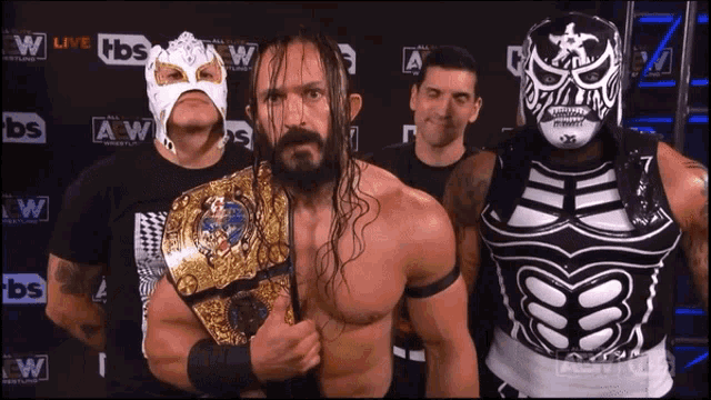 a group of wrestlers standing in front of a wall that says tbs live