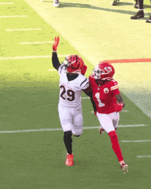 a football player with the number 29 on his jersey is being tackled by another player