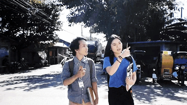 a man and a woman are walking down a street and the man has a name tag that says ' amanda ' on it