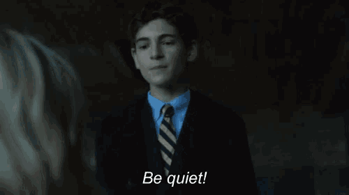 a man in a suit and tie says be quiet