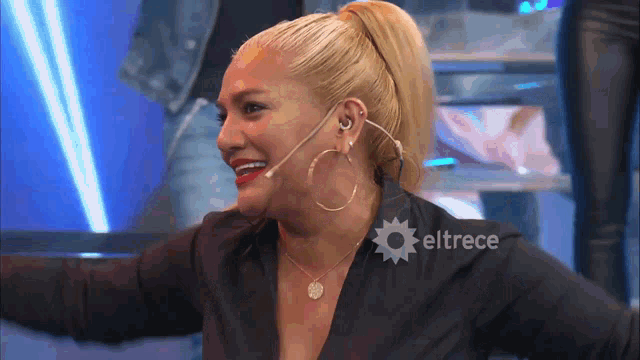 a woman in a black shirt with eltrece on the bottom right
