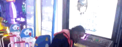 a person is playing a video game in an arcade and looking at the screen
