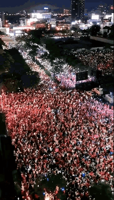 a large crowd of people are gathered in front of a large screen
