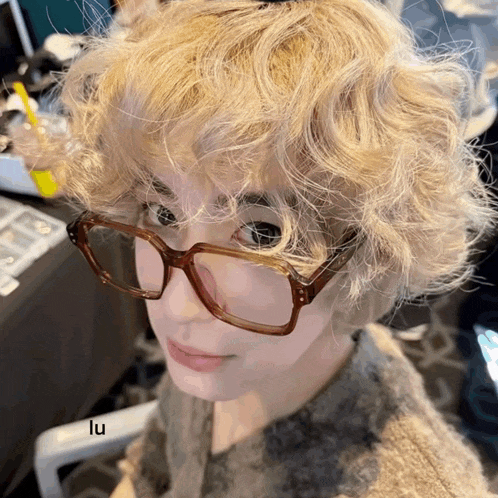 a close up of a person wearing glasses with the letters lu on the bottom right