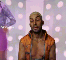 a man without a shirt is standing in front of a wall with polka dots .