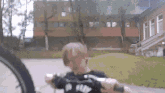 a boy riding a bike with a shirt that says no bully