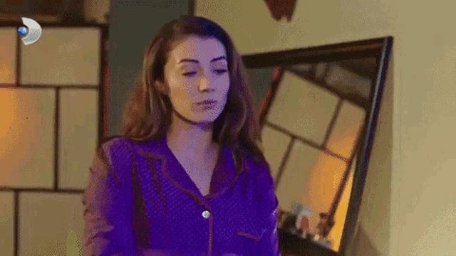 a woman is standing in front of a mirror in a room .