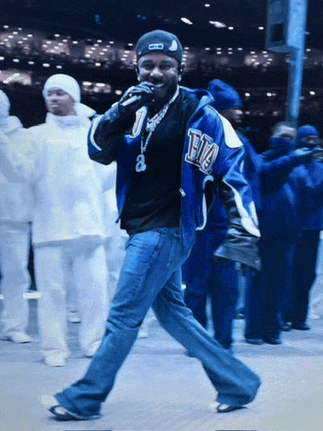 a man wearing a blue jacket with the letter t on it