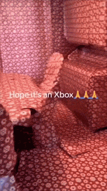 a room covered in wrapping paper with the words hope it 's an xbox aa