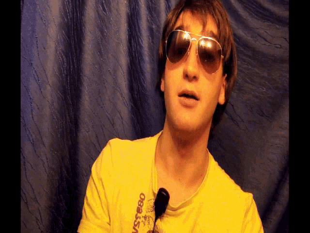 a man wearing sunglasses and a yellow shirt that says obser on it