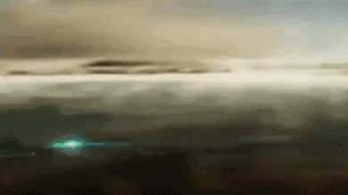 a green light is shining in the middle of a cloudy sky