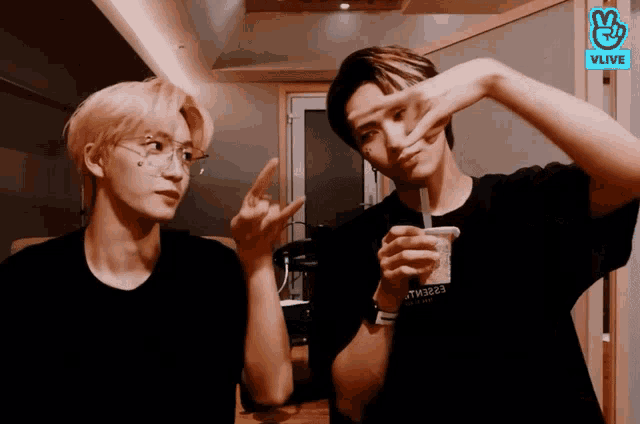 two young men are making funny faces in front of a sign that says vlive on it