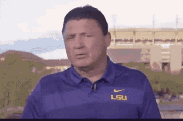 a man wearing a purple shirt with lsu on the front