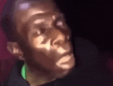 a close up of a man 's face with a blurred background and a shadow on his face .