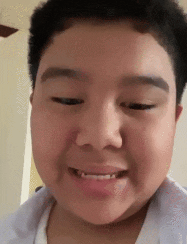 a close up of a young boy 's face with a smile on it .
