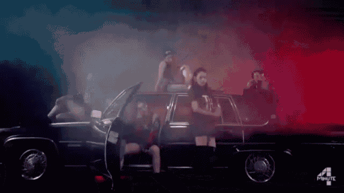 a group of people are standing around a car with the number 4 on the side