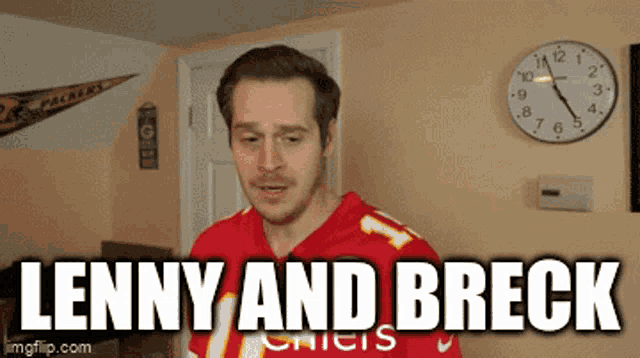 a man in a red jersey is standing in front of a clock that says lenny and breck