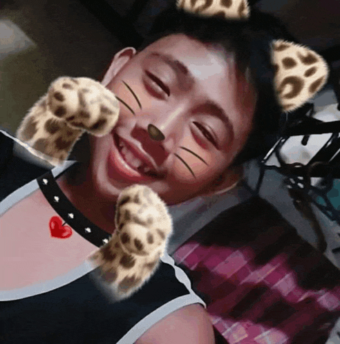 a young man wearing a cat mask with paws on his face and a heart on his chest