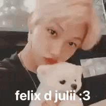 a young man is holding a white teddy bear in his arms .