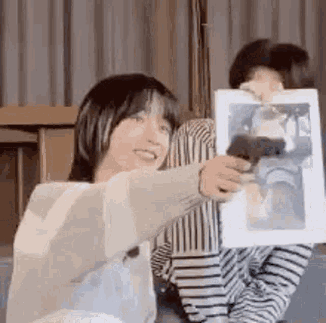 a woman is holding a picture of a dog in her hands .