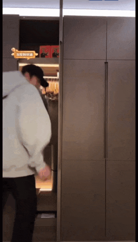 a man is standing in front of a refrigerator with chinese writing on it .