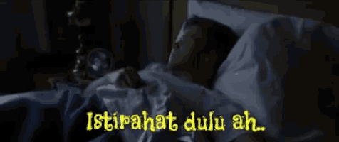 a man is laying in bed with the words istirahat dulu ah