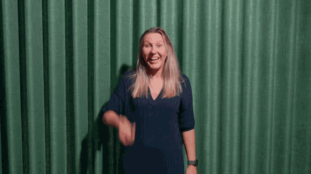 a woman in a blue shirt is throwing confetti at the camera