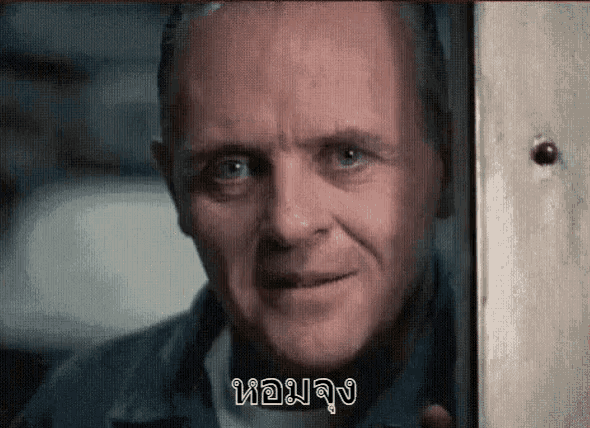 a close up of a man 's face looking out of a window and smiling .