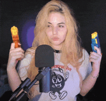 a woman wearing a shirt that says destroy five is holding a toy gun in front of a microphone