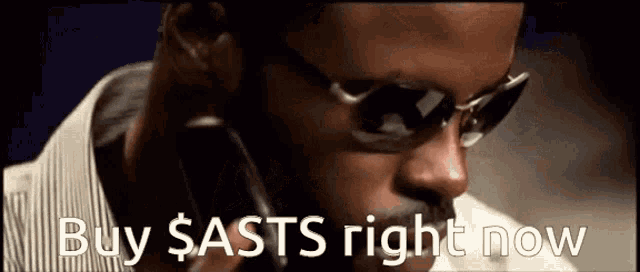 a man wearing sunglasses has the words buy sasts right now above his head