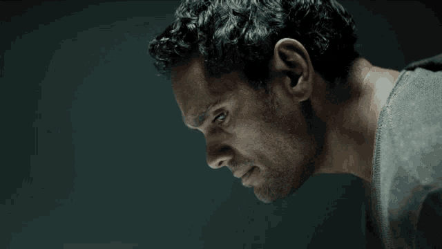 a close up of a man 's face with a gray shirt on