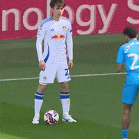 a soccer player wearing a white jersey with red bull on it