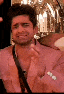 a man in a pink suit is making a funny face with his eyes closed