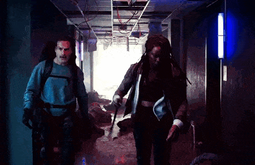 a man and a woman are walking down a hallway with a sword .
