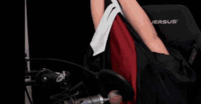 a person sitting in a versus chair with their arm outstretched