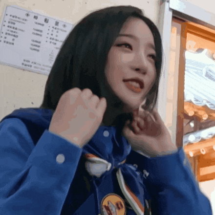 a girl wearing a blue shirt with a badge that says ' korean ' on it