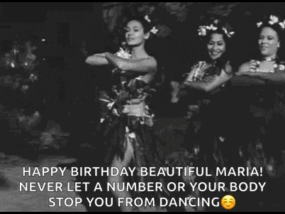 a woman is dancing in a black and white photo with flowers in her hair .