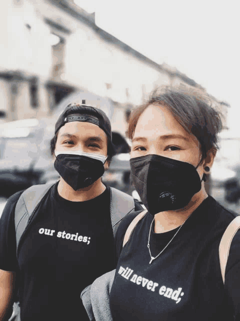 a man and a woman wearing face masks and t-shirts that say our stories will never end