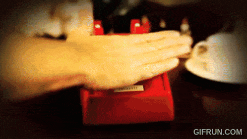 a gif from gifrun.com shows a person pressing a button on a red telephone