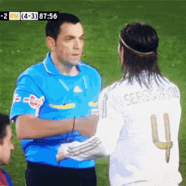 a soccer player wearing a number 4 jersey shakes hands with another player